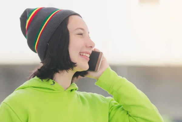 portrait of a beautiful young girl wearing a neon jacket and calling on the phone, dialling an 0435 number on Vodafone