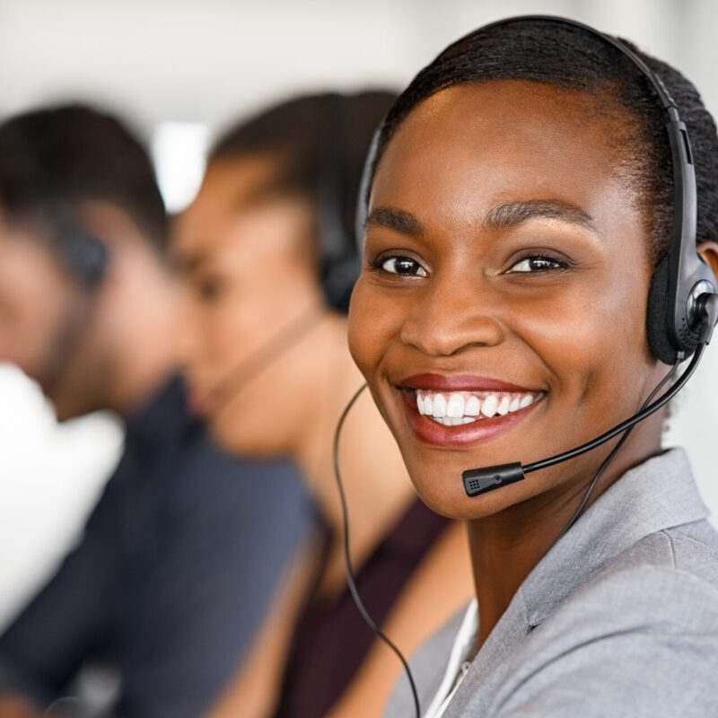 Black mature customer service woman on call with big smile