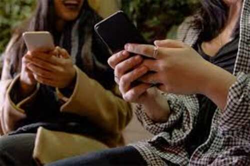 Two woman holding cellphones