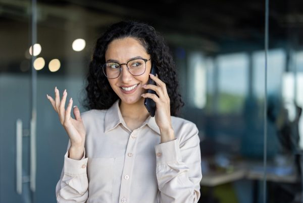 professional woman talking on phone in modern office, calling 0300 number on TalkTalk