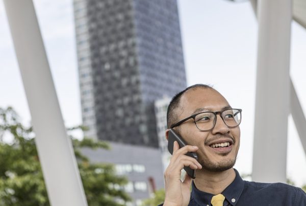 A man calling a 0300 number on his phone, having Tesco Mobile as his network