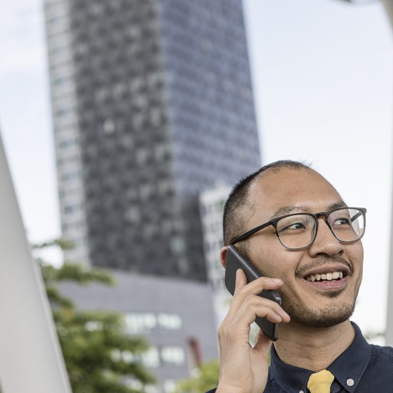 A man calling a 0300 number on his phone, having Tesco Mobile as his network