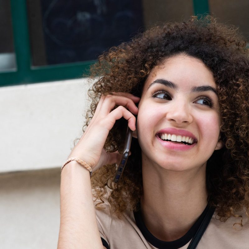 Close-up of a beautiful young woman talking on the phone. Calling an 0300 number on EE.