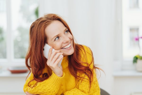 Happy red haired woman talking on a mobile